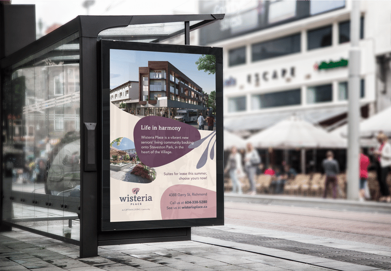 A street-level mockup of a bus shelter billboard advertisement featuring a real-world branding example for a seniors' living development named "Wisteria Place," showcasing how a new name looks in active marketing campaigns.